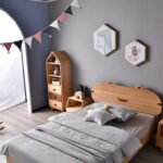Complete kids bedroom interior featuring solid wood bear eared single bed frame nightstand house bookshelf and grey wall bunting.