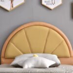 Close-up detail of mustard yellow fan shaped padded headboard on solid wooden kids bed frame