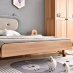 Close-up detail of solid wood kids bed frame and smooth rounded edge leg base with sheep decorative toys on nursery rug