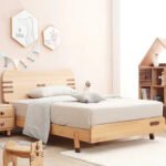 Side perspective of a solid wood single bed frame featuring horizontal slat cut-outs and a playful bone-shaped central headboard accent.