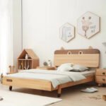 Angled perspective of a solid wood kids' bed with a playful animal-ear headboard design, complete with circular cut-outs and rounded corners.