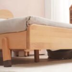 Close-up detail shot highlighting the smooth rounded frame corner and sturdy wooden leg construction with protective dark foot caps.