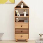 Centered front view of the tall narrow house-shaped cabinet featuring two open display compartments at the top and three pull-out drawers below with contrasting wooden fronts.