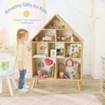 A young girl standing next to the Amyzel house-shaped wooden bookshelf, utilizing the open cubby compartments as a multi-level toy dollhouse.