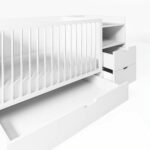 Angled studio shot demonstrating the pull-out storage features of a white convertible baby crib, showing the large bottom drawer and side dresser drawers fully extended.