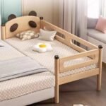 Panda-themed bedside crib for newborns designed for easy night-time access in nursery spaces.