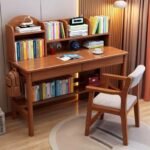 Honey oak solid wood children's study desk set featuring a top shelving hutch, dual drawers, lower bookshelf rail, and a matching wooden chair with a white seat pad.