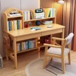 Natural pine wood study desk set with an integrated top bookshelf hutch, dual pull-out drawers, bottom shelf, and a matching natural timber chair with armrests.