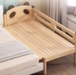 High-angle view of an unmade panda-themed solid wood toddler bed frame, showcasing the slatted wooden mattress support base and carved panda-ear headboard.