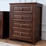 Tall dark wood 4-drawer chest of drawers positioned against a white paneled wall next to another matching dark wood piece.