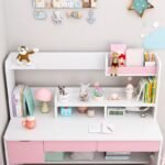 Angled close-up view of the white and pink study desk hutch filled with books, desk lamps, alarm clocks, and colorful stationery.