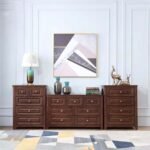 Room setting featuring three matching dark wood dressers arranged side-by-side (a 4-drawer chest on each side of the wide 6-drawer dresser), styled with a table lamp, vases, deer figurines, and artwork.