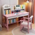 Pink wooden kids' study desk featuring an integrated multi-compartment bookshelf hutch, two pull-out drawers, a lower storage shelf, and a matching pink ergonomic wooden chair with a cushioned seat.