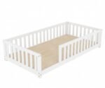 Minimalist white painted wooden toddler floor bed frame with an open front entry section and full slatted guardrails, isolated on a clean white background.