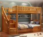 natural wooden bunk bed with storage stairs with built-in bookshelf cubbies and under-bed drawers.