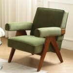 Olive green velvet upholstered armchair featuring an angled wooden V-frame structure and thick padded arm cushions.