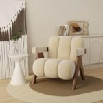 Ivory cream channel-tufted lounge chair featuring dark wood V-legs placed on a layered round carpet with minimalist decor.