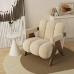 Ivory cream channel-tufted lounge chair featuring dark wood V-legs placed on a layered round carpet with minimalist decor.