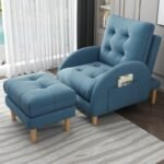 Soft blue plush recliner chair and footrest set accessorized with a cloud pillow in a cozy bedroom window reading nook.