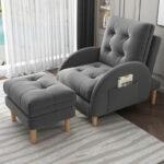 Soft dark grey plush recliner chair and footrest set accessorized with a cloud pillow in a cozy bedroom window reading nook.