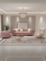 Luxury living room arrangement featuring a mauve pink channel-tufted sofa, matching armchair, creamy white button-tufted accent chair, marble coffee tables, and a crystal chandelier.