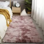 Blush pink tie dye fluffy runner rug for bedroom, soft pastel mauve shag carpet runner, cozy bedside plush floor mat next to platform bed.