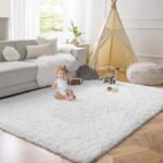 Amyzel classic white fluffy shag rug for toddler nursery, ultra soft thick pile children's playroom carpet styled next to a grey sectional sofa and canvas play teepee tent.
