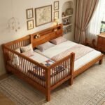 Natural finish wooden bedside crib and toddler cot extension attached to a parent bed, showcasing a modern, minimalist design with cozy earth-toned bedding.