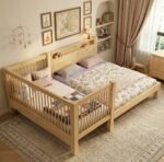 Elegant light pine -finished wood co-sleeping toddler bed extension attached to a larger parents' bed, highlighting a clean, scandinavian-inspired nursery design.